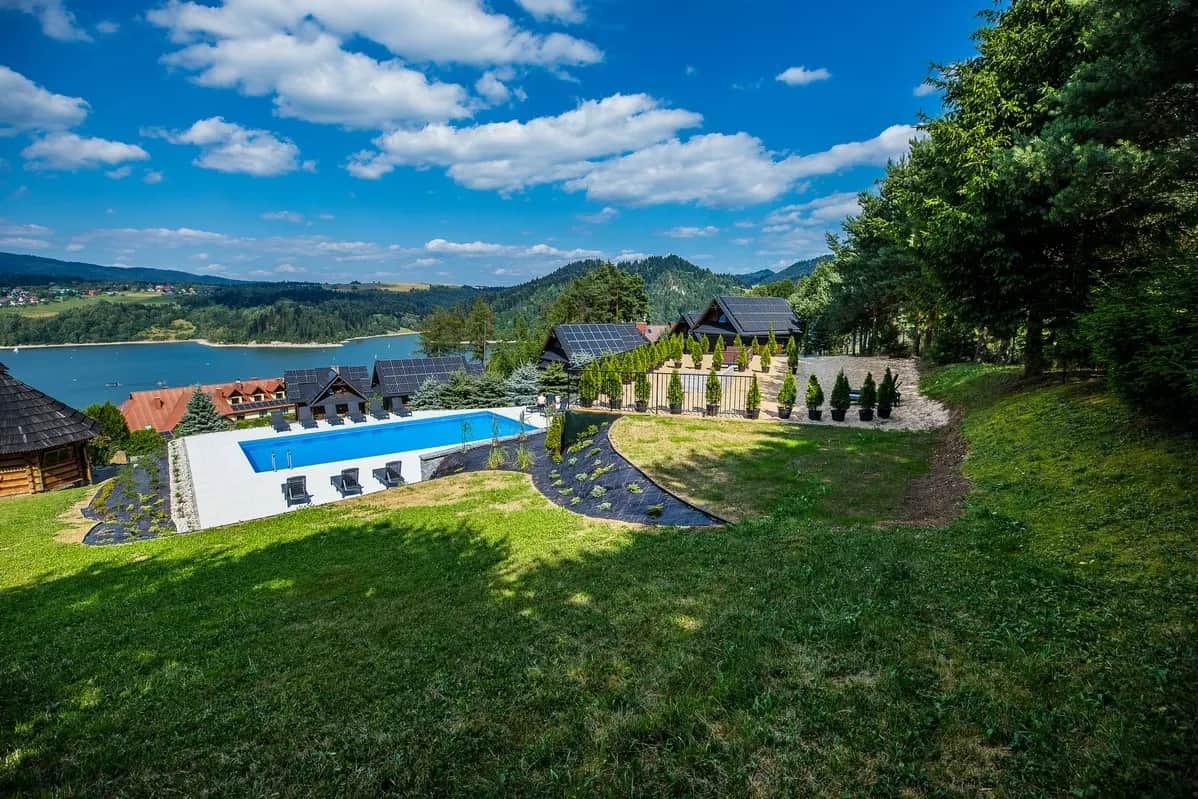 Słoneczny dzień przy basenie z panoramą doliny i jeziora
