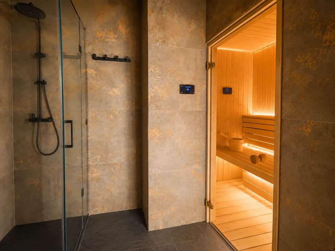 Strefa wellness - prysznic i wejście do drewnianej sauny z podświetleniem