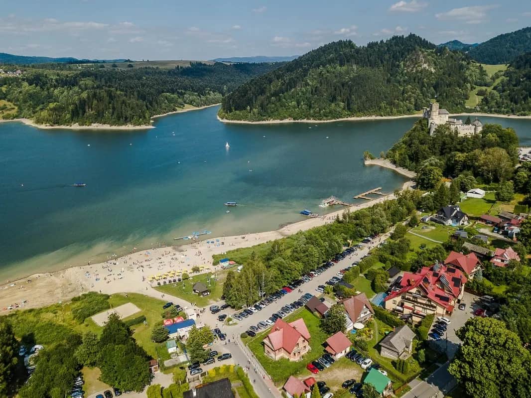 Zamek na cyplu nad jeziorem i plaża widziane z lotu ptaka
